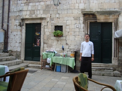 Waiter standing by the entrance to a cafe - Dubrovnik, Croatia